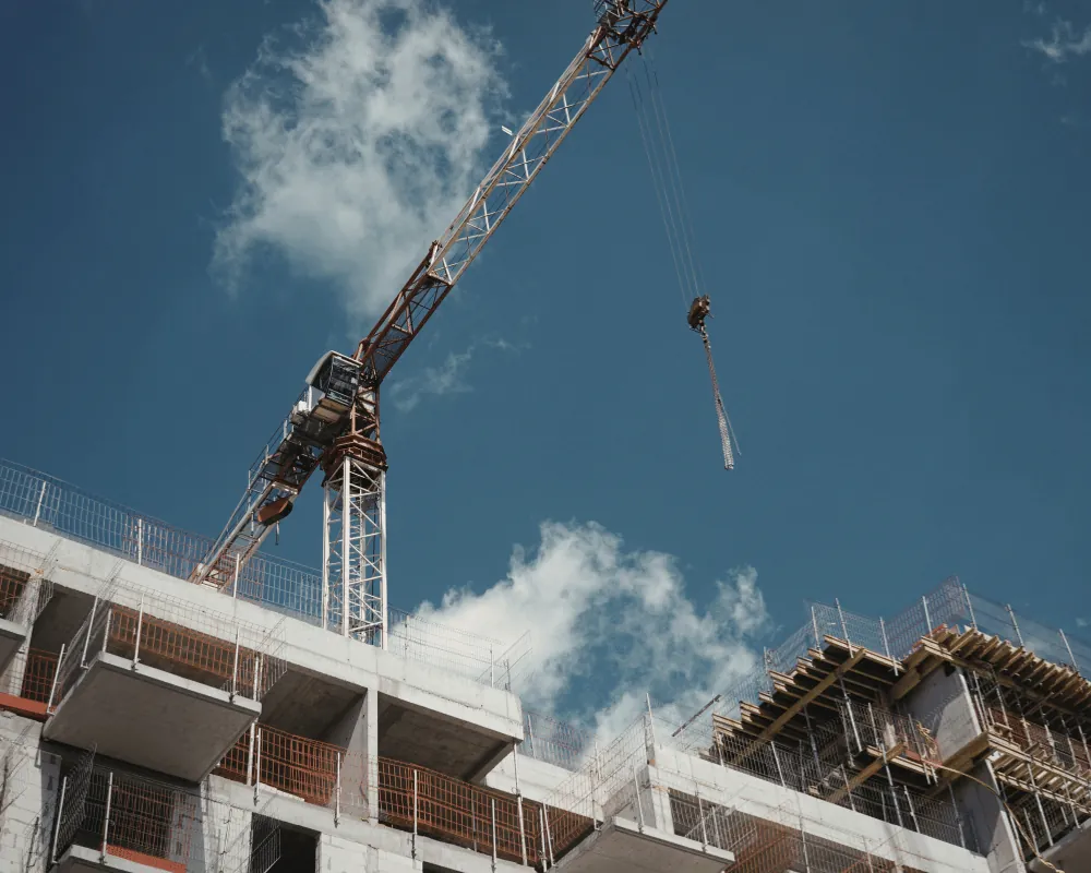 Rebuilding Syria: construction crane beside a building under construction against a blue sky